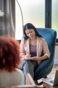 Therapist making notes while listening to client