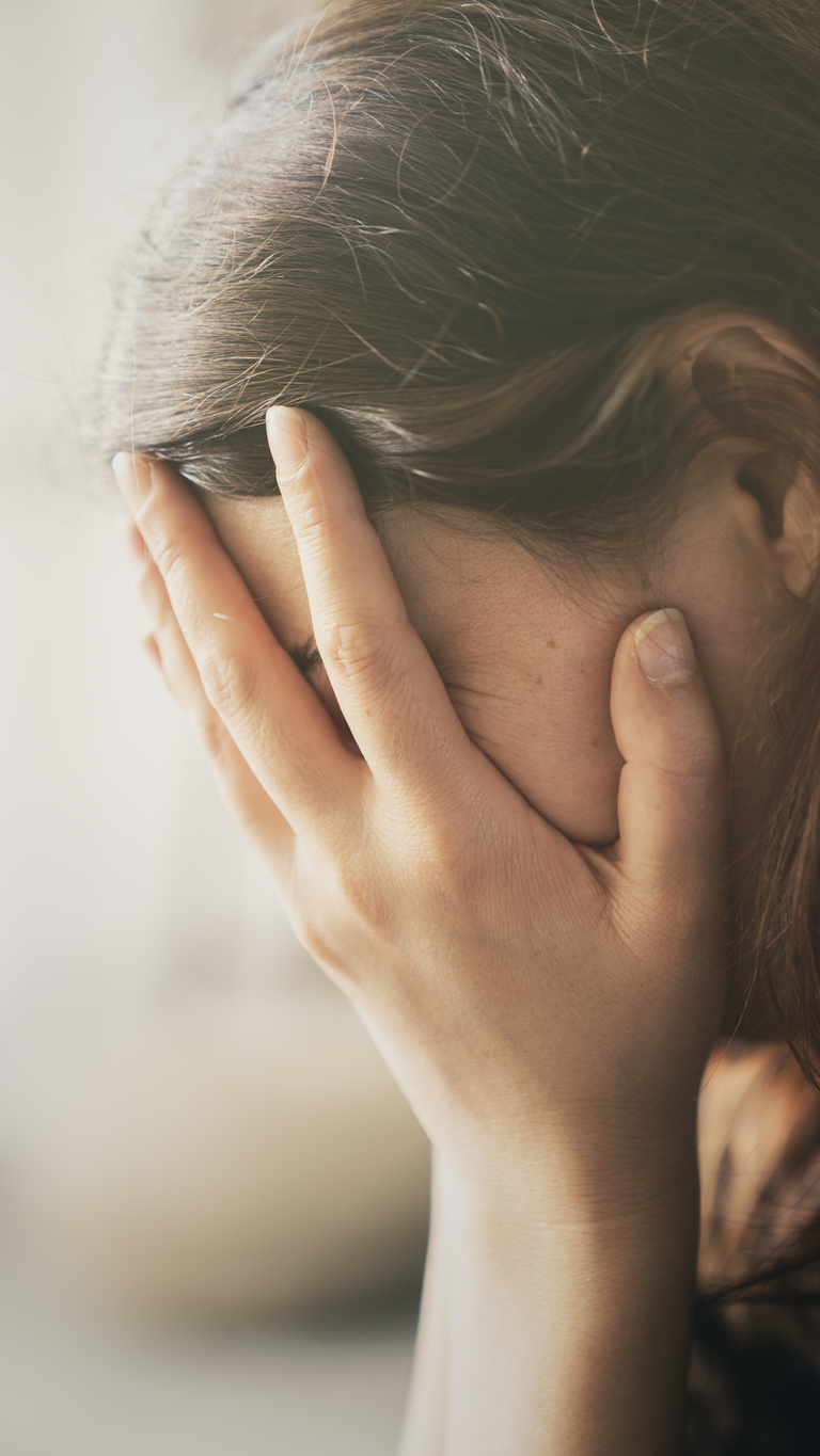 a woman cover her face feeling sad and depressed