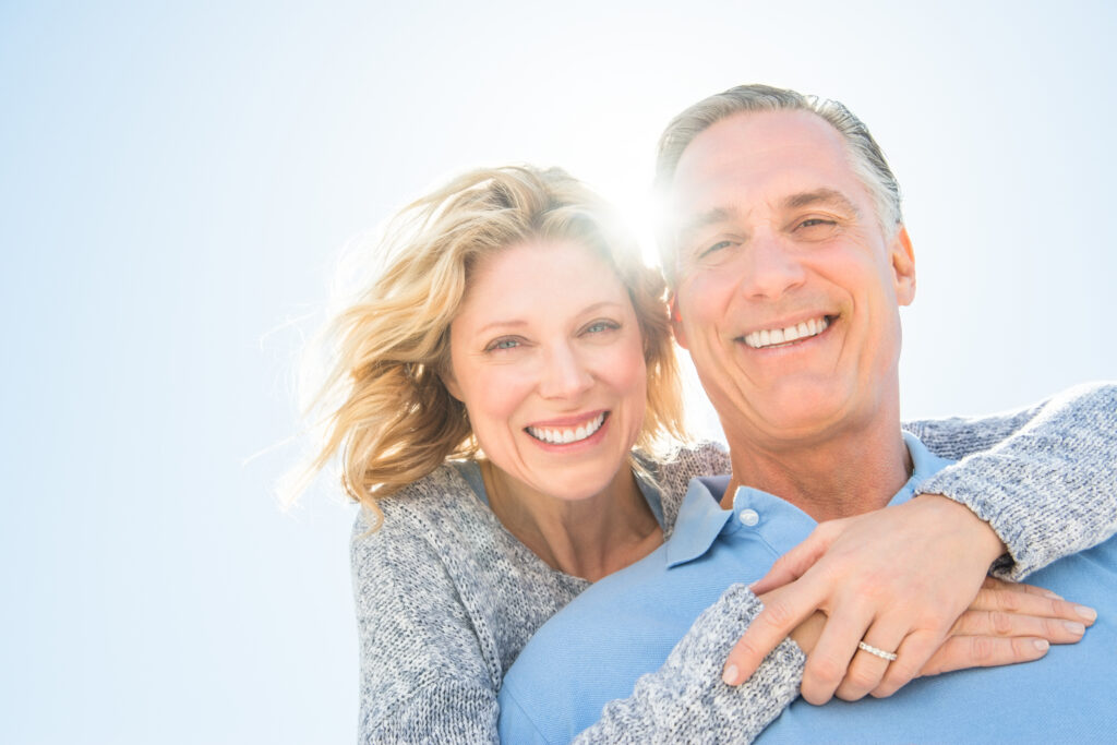 Low angle portrait of happy mature couple against clear sky