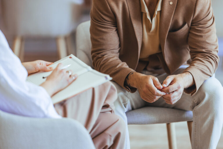 A professional therapist conducts a counseling session with a male client