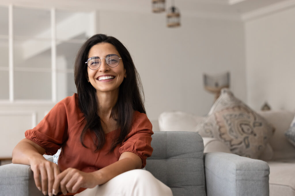 smiling woman sitting on the sofa at home